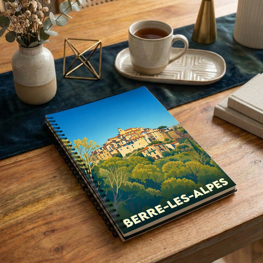 Carnet à spirales souvenir de la ville de Berre-les-Alpes avec une illustration stylisée de son village perché.