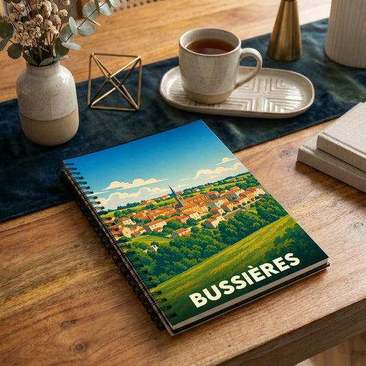 Carnet à spirales souvenir de la ville de Bussières avec une illustration stylisée de son paysage.
