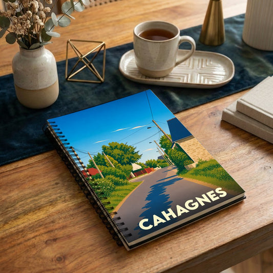 Carnet souvenir de la ville de Cahagnes avec une illustration stylisée d'une rue ensoleillée.