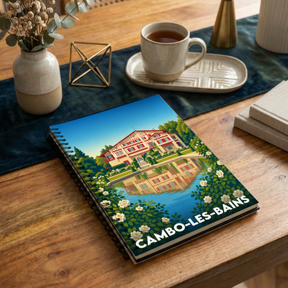 Carnet à spirale souvenir de Cambo-les-Bains illustré d'une vue stylisée de la Villa Arnaga se reflétant dans l'eau.