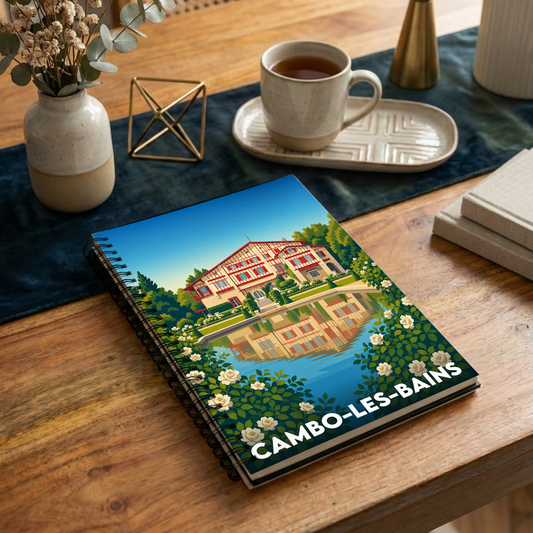 Carnet à spirale souvenir de Cambo-les-Bains illustré d'une vue stylisée de la Villa Arnaga se reflétant dans l'eau.