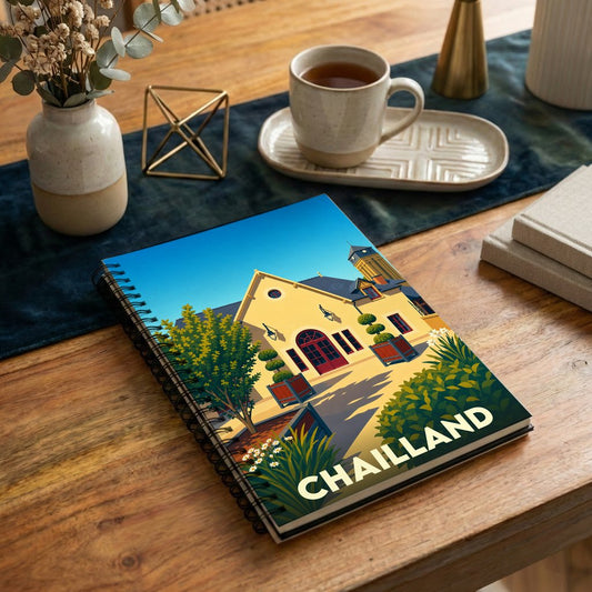 Carnet de notes souvenir de la ville de Chailland avec une illustration stylisée et colorée de son architecture.