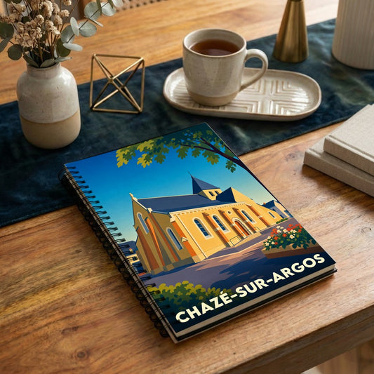 Carnet souvenir de la ville de Chazé-sur-Argos avec une illustration stylisée de son église sous un ciel bleu.
