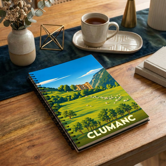 Carnet à spirales souvenir de la ville de Clumanc avec une illustration stylisée de paysages vallonnés.