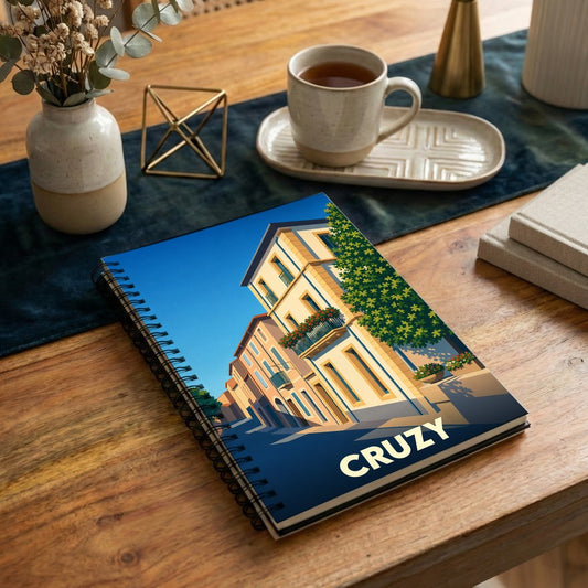 Carnet souvenir de la ville de Cruzy avec une illustration stylisée d'une rue ensoleillée.