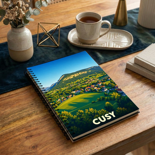 Carnet souvenir de la ville de Cusy avec une illustration stylisée d'un paysage montagneux.