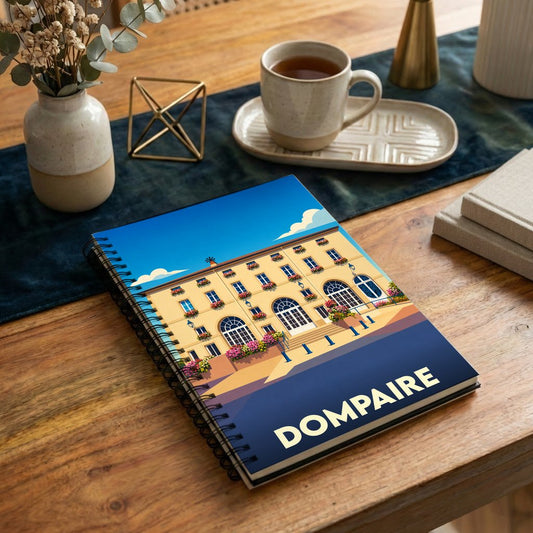 Carnet à spirales souvenir de la ville de Dompaire avec une illustration stylisée d'un bâtiment fleuri.