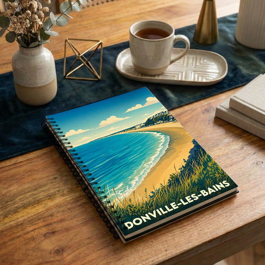 Carnet souvenir de la ville de Donville-les-Bains avec une illustration stylisée d'une plage vue de dessus.