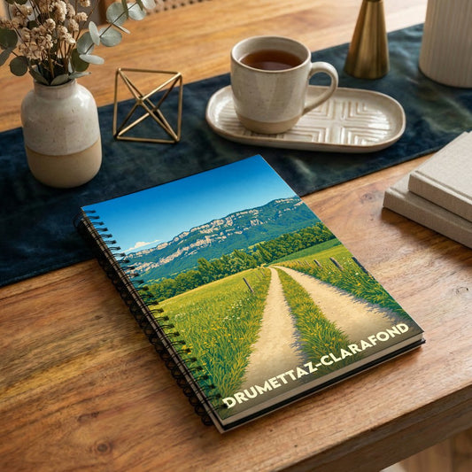 Carnet de notes souvenir de la ville de Drumettaz-Clarafond avec une illustration stylisée de paysage champêtre.