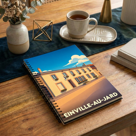 Carnet à spirales souvenir de la ville de Einville-au-Jard avec une illustration architecturale stylisée.