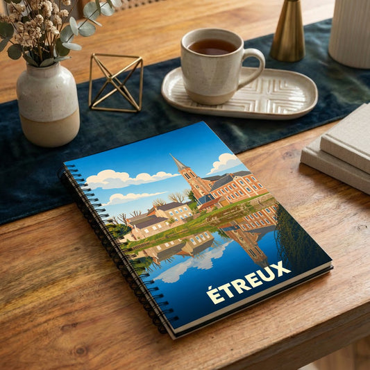 Carnet à spirales souvenir de la ville d'Étreux avec une illustration stylisée du village et de son reflet sur l'eau.