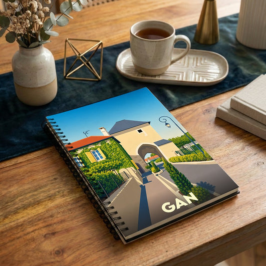Carnet à spirale souvenir de la ville de Gan avec une illustration stylisée de son architecture.