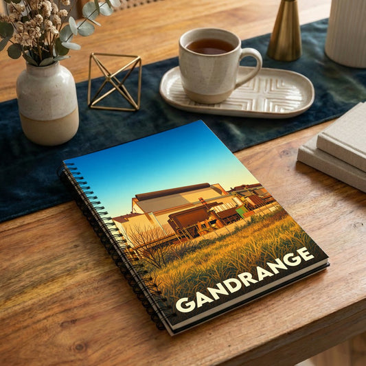 Carnet souvenir de la ville de Gandrange avec une illustration stylisée d'un site industriel au coucher du soleil.