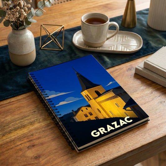 Carnet de notes souvenir de la ville de Grazac avec une illustration stylisée d'une église sous un ciel nocturne.
