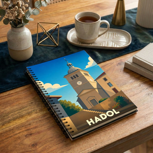Carnet de notes souvenir de la ville de Hadol avec une illustration stylisée d'un clocher.