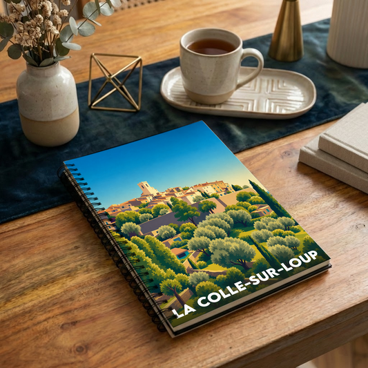 Carnet à spirales souvenir de la ville de La Colle-sur-Loup avec une illustration stylisée d'un village provençal.