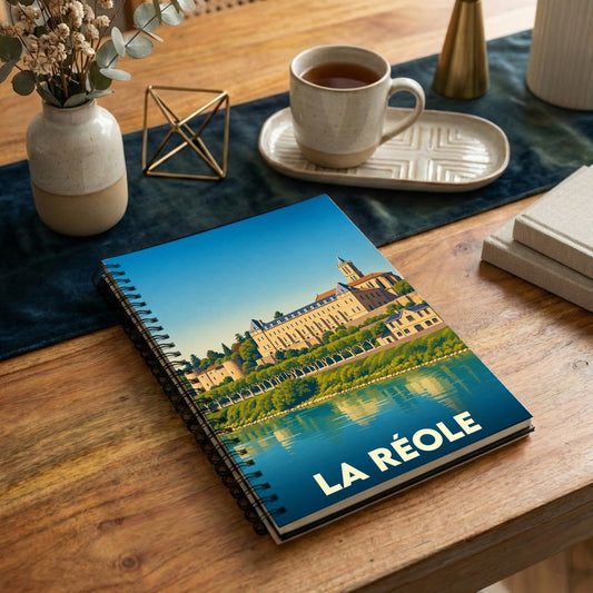 Carnet à spirales souvenir de la ville de La Réole avec une illustration stylisée de son patrimoine en bord de Garonne.