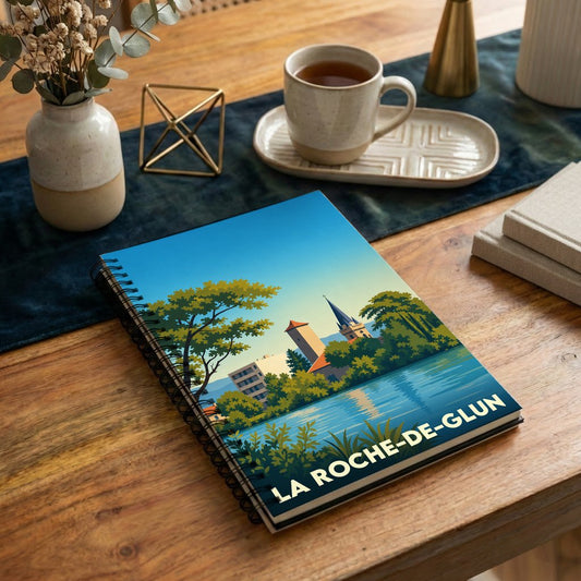 Carnet de notes à spirales avec une illustration stylisée de la ville de La Roche-de-Glun en bord de l'eau.