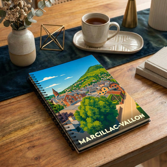Carnet à spirales souvenir de Marcillac-Vallon avec une illustration stylisée de la ville.