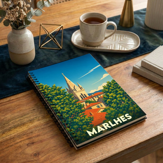 Carnet à spirales souvenir de la ville de Marlhes avec une illustration stylisée de son église et de ses toits.