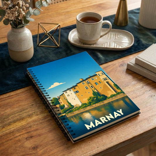 Carnet à spirales souvenir de la ville de Marnay avec une illustration stylisée d'un paysage urbain au bord de l'eau.