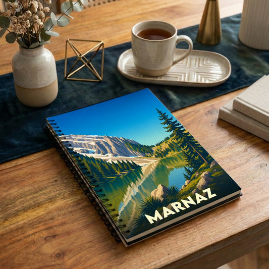Carnet à spirales souvenir de la ville de Marnaz avec une illustration stylisée de paysage alpin.