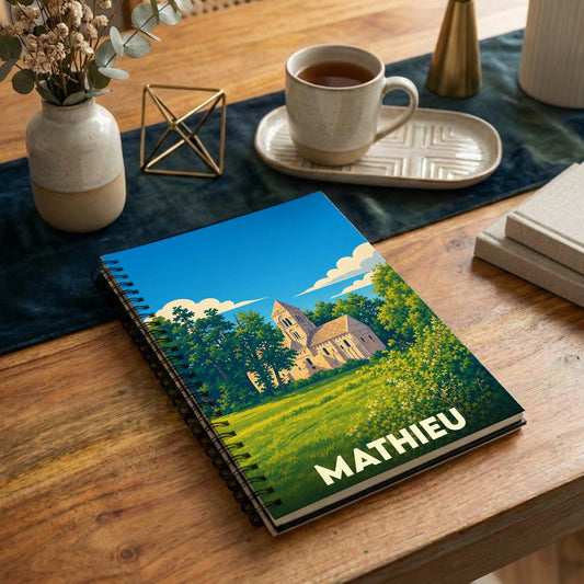 Carnet de notes à spirales souvenir de la ville de Mathieu avec une illustration stylisée de son église.