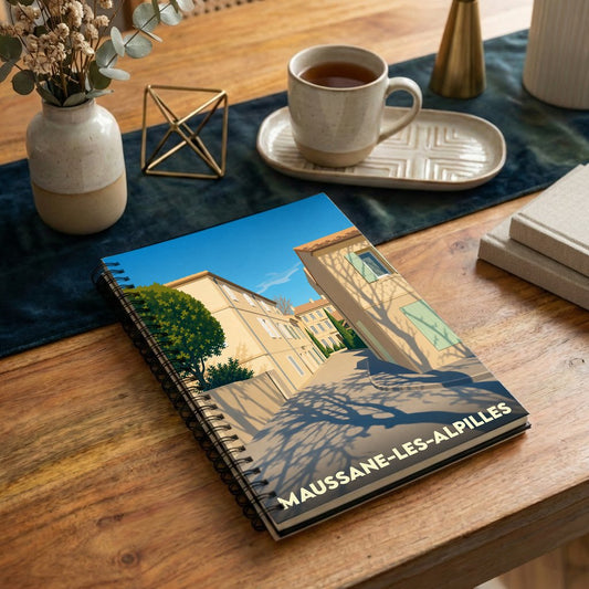Carnet à spirales souvenir de Maussane-les-Alpilles avec une illustration ensoleillée d'une ruelle provençale.
