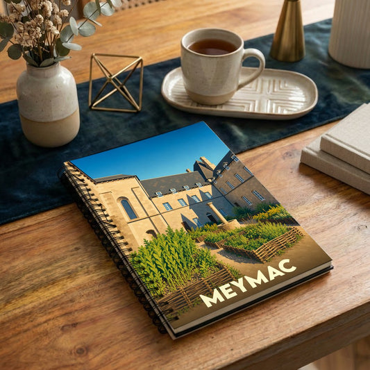 Carnet à spirales souvenir de la ville de Meymac avec une illustration stylisée de son abbaye et de ses jardins.