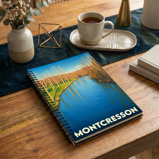 Carnet à spirales souvenir de la ville de Montcresson avec une illustration stylisée d'un paysage de rivière.