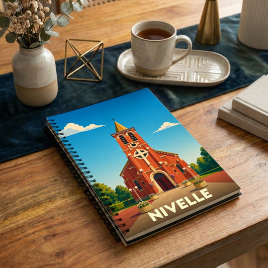 Carnet à spirale souvenir de la ville de Nivelle illustré d'une église stylisée sous un ciel bleu.