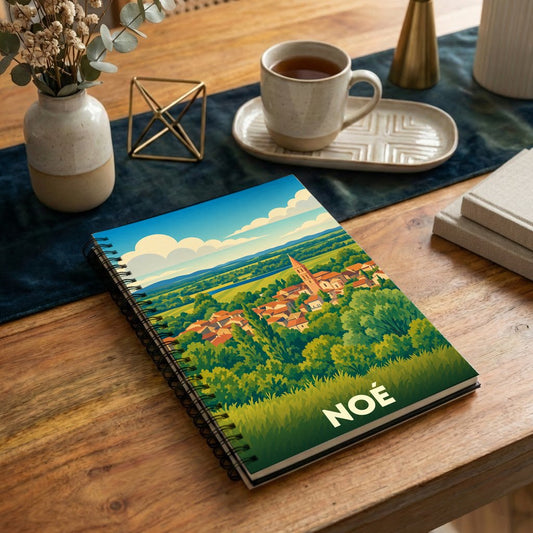 Carnet à spirale souvenir de la ville de Noé avec une illustration stylisée de son paysage urbain et verdoyant.
