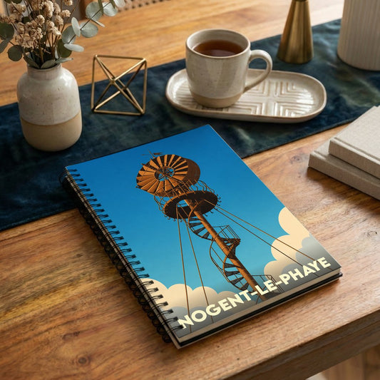 Carnet à spirales souvenir de Nogent-le-Phaye illustré d'une haute structure métallique stylisée sous un ciel bleu.