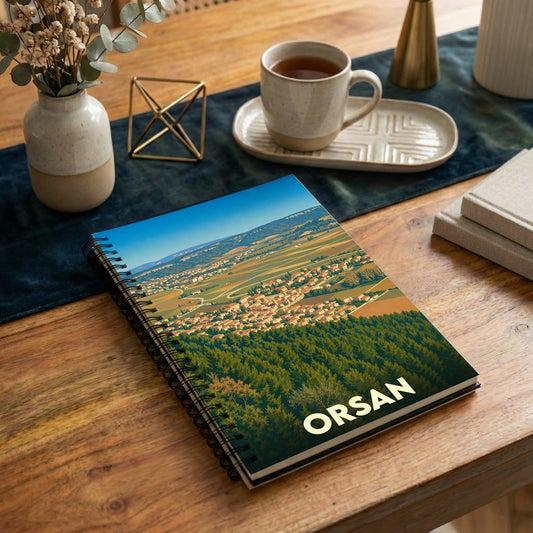 Carnet souvenir de la ville d'Orsan avec une illustration stylisée de son paysage.