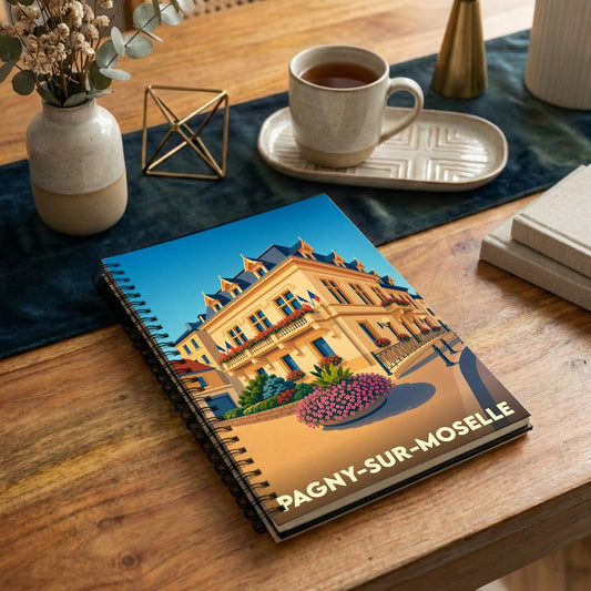 Carnet à spirales souvenir de la ville de Pagny-sur-Moselle avec une illustration stylisée de son hôtel de ville.
