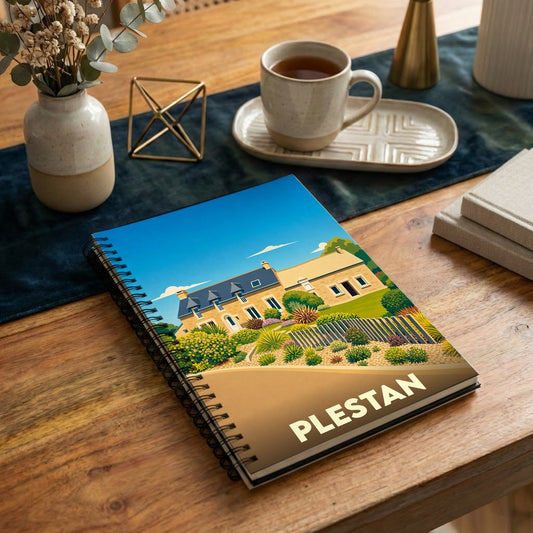 Carnet à spirales souvenir de la ville de Plestan avec une illustration stylisée d'une maison traditionnelle.