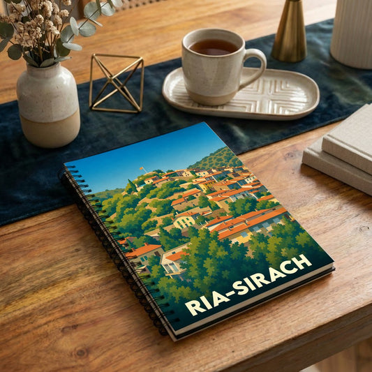 Carnet à spirales souvenir de la commune de Ria-Sirach avec une illustration stylisée de ses maisons colorées à flanc de colline.
