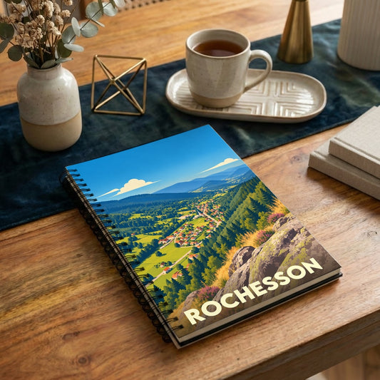 Carnet à spirales souvenir de la ville de Rochesson avec une illustration stylisée de son paysage montagneux.