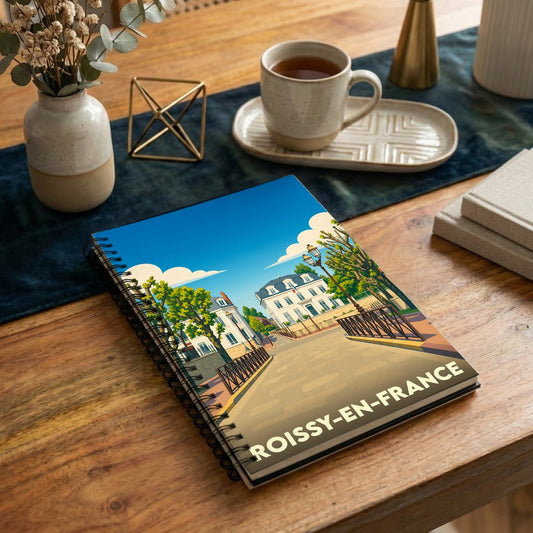 Carnet à spirales souvenir de la ville de Roissy-en-France avec une illustration stylisée.