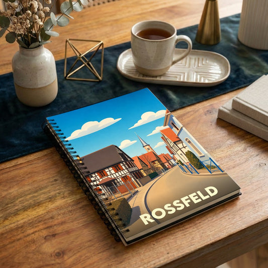 Carnet à spirales souvenir de la ville de Rossfeld avec une illustration stylisée d'une rue typique.