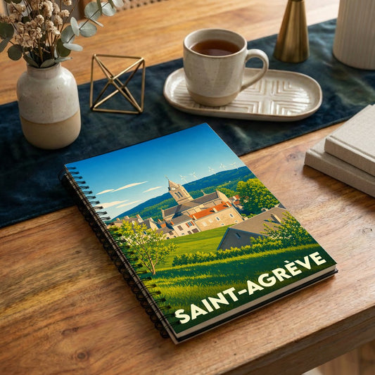 Carnet de notes à spirales souvenir de la ville de Saint-Agrève avec une illustration stylisée d'un paysage urbain.