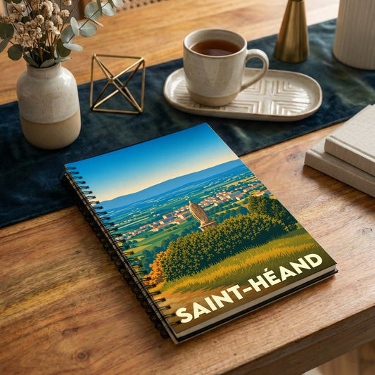 Carnet à spirales souvenir de la ville de Saint-Héand avec une illustration de paysage stylisée.