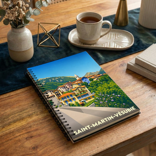 Carnet à spirales souvenir de Saint-Martin-Vésubie avec une illustration colorée et stylisée du village.