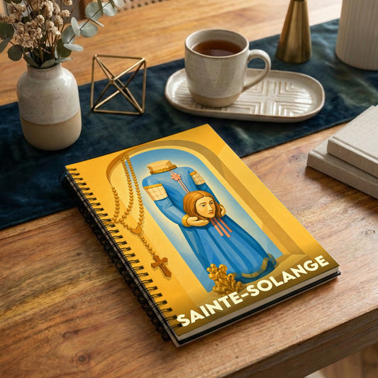 Carnet à spirales souvenir de la ville de Sainte-Solange illustrant sa sainte patronne céphalophore.