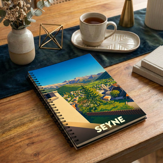 Carnet à spirales souvenir de la ville de Seyne avec une illustration paysagère stylisée.