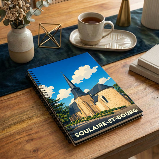 Carnet de notes à spirales avec une illustration stylisée de l'église de Soulaire-et-Bourg sous un ciel bleu.