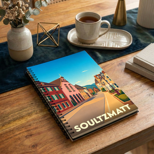 Carnet à spirales souvenir de la ville de Soultzmatt avec une illustration stylisée de ses rues colorées.