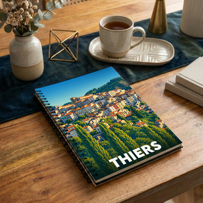 Carnet souvenir de la ville de Thiers avec une illustration stylisée et colorée.