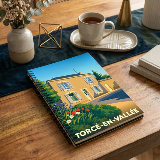 Carnet souvenir de la ville de Torcé-en-Vallée avec une illustration stylisée d'une maison fleurie.