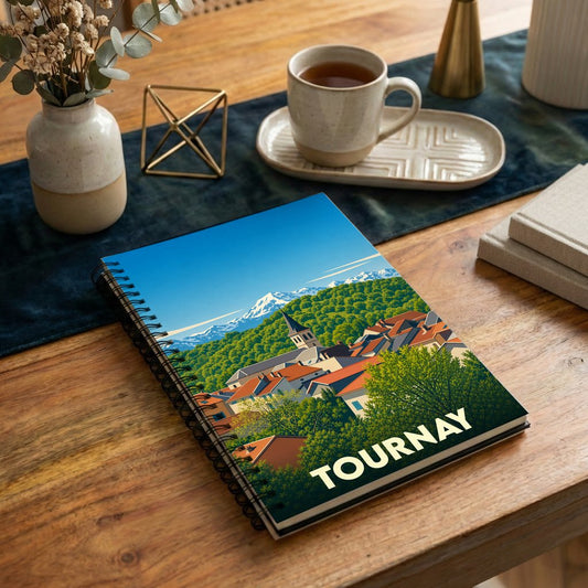 Carnet à spirales souvenir de la ville de Tournay avec une illustration stylisée de ses toits face aux montagnes.